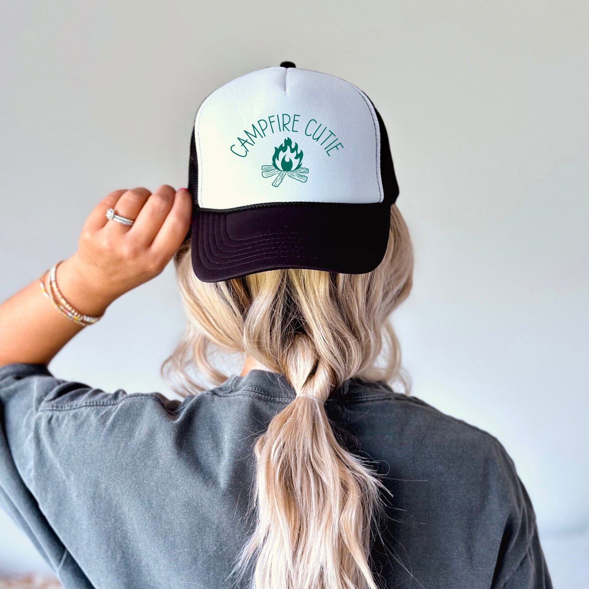 a woman with a ponytail wearing a black and white hat